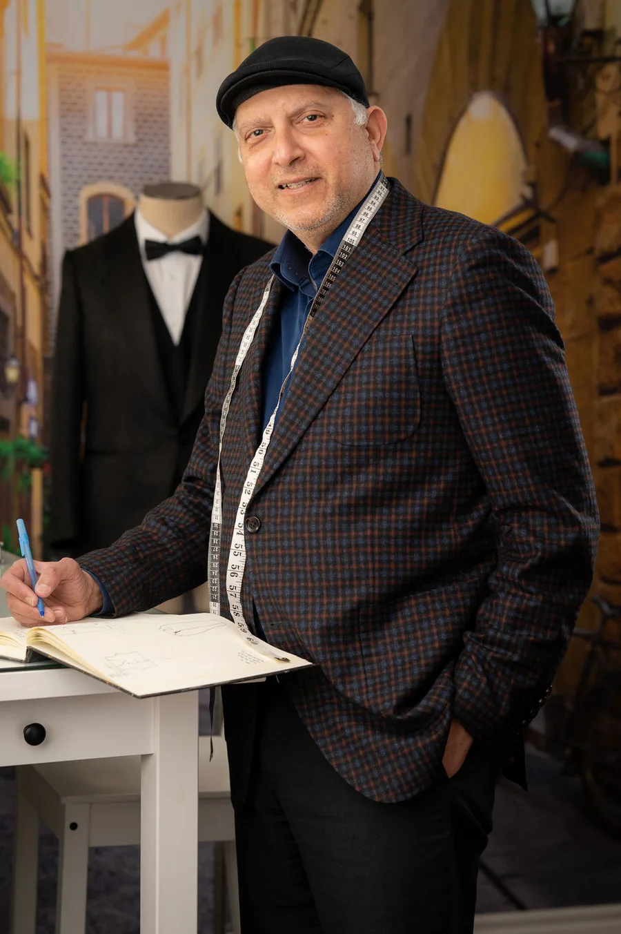 Sam Talkar, master tailor, tape measure around his neck, sketching a pattern at the studio in Vaughan